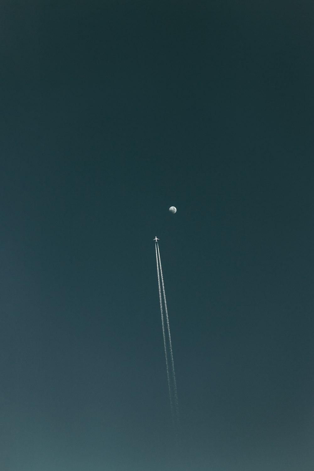 flying plane with contrail during nighttime