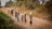 A group of smiling children drinking clean water from a newly installed well in a rural community.