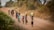 A group of smiling children drinking clean water from a newly installed well in a rural community.
