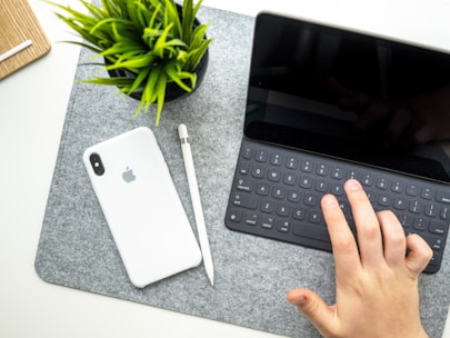 A creative workspace with a person interacting with an AI-powered virtual assistant on a tablet.