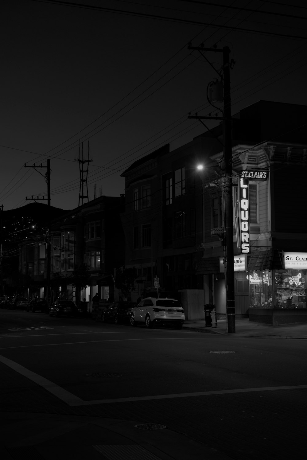 grayscale photo of white car park beside road