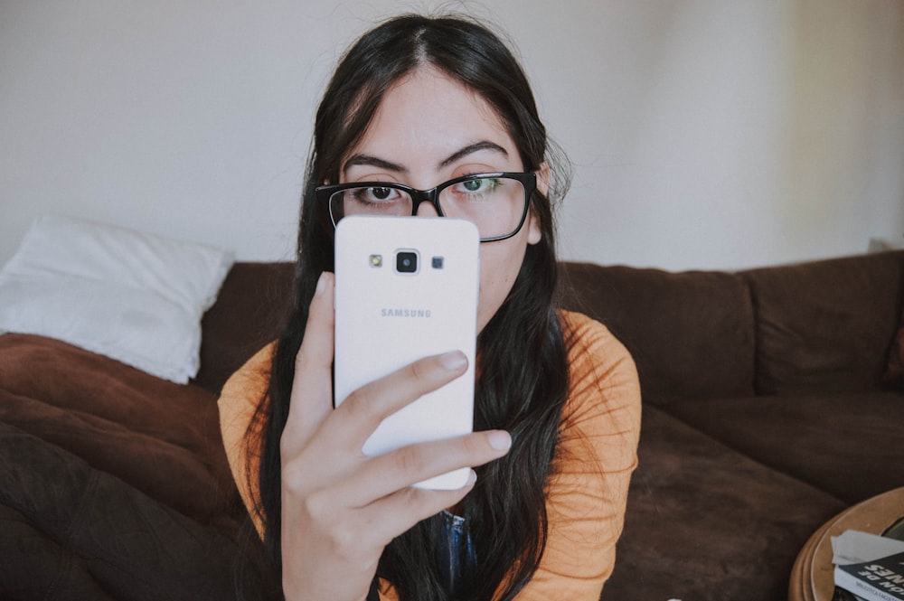 woman holding white Samsung Android smartphone