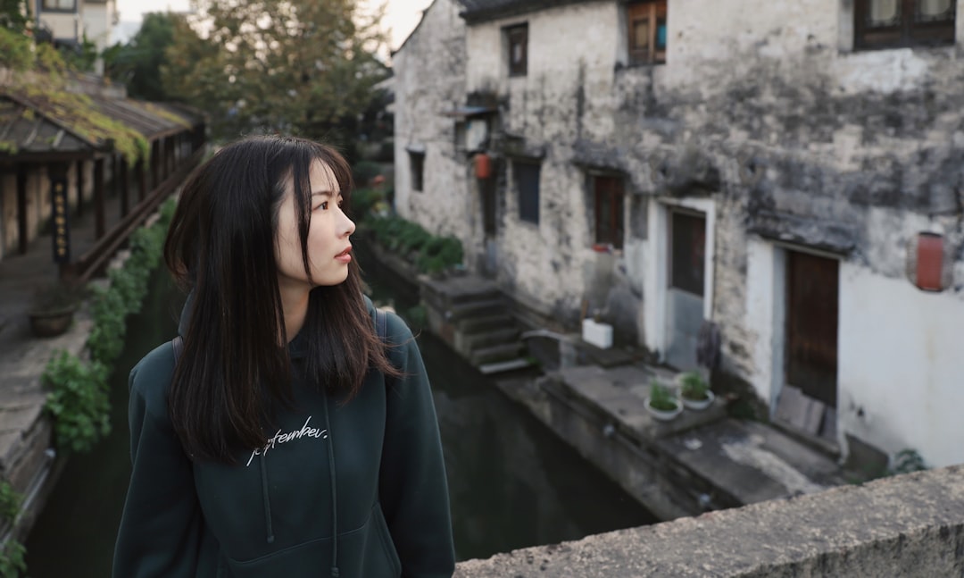 woman standing on bridge near houses