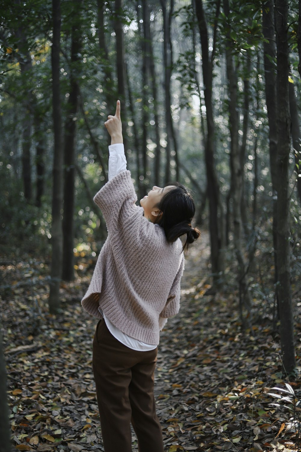 man raising her hand up high outdoors