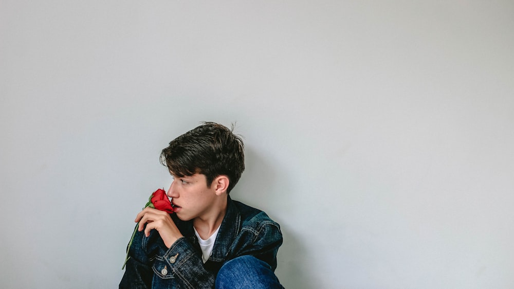 man sitting near white wall