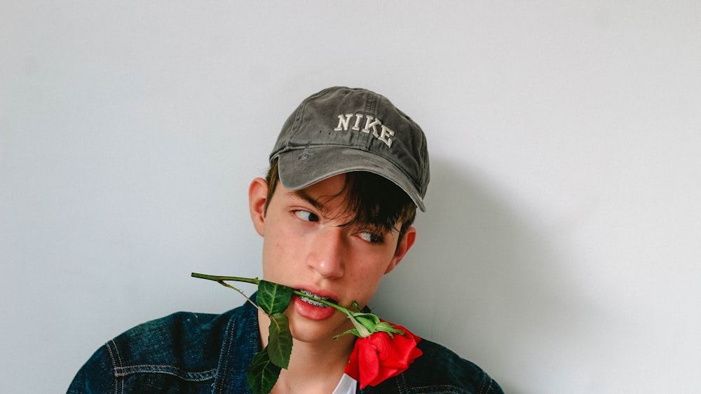 man biting red rose