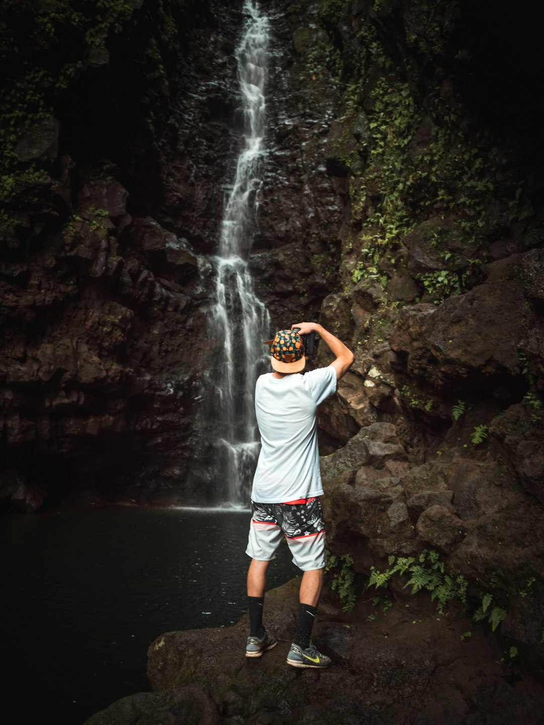 man taking picture of waterfalls