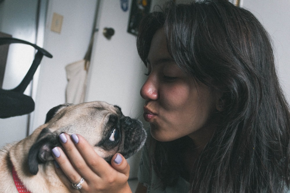 woman about to kiss dog