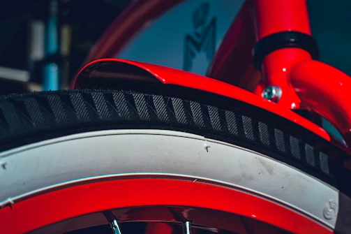 A vibrant red bicycle frame coated with powder paint, highlighting the even coverage and shine.