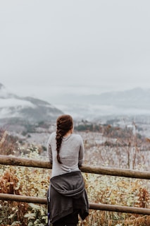 standing woman in grey long-sleeved shirt