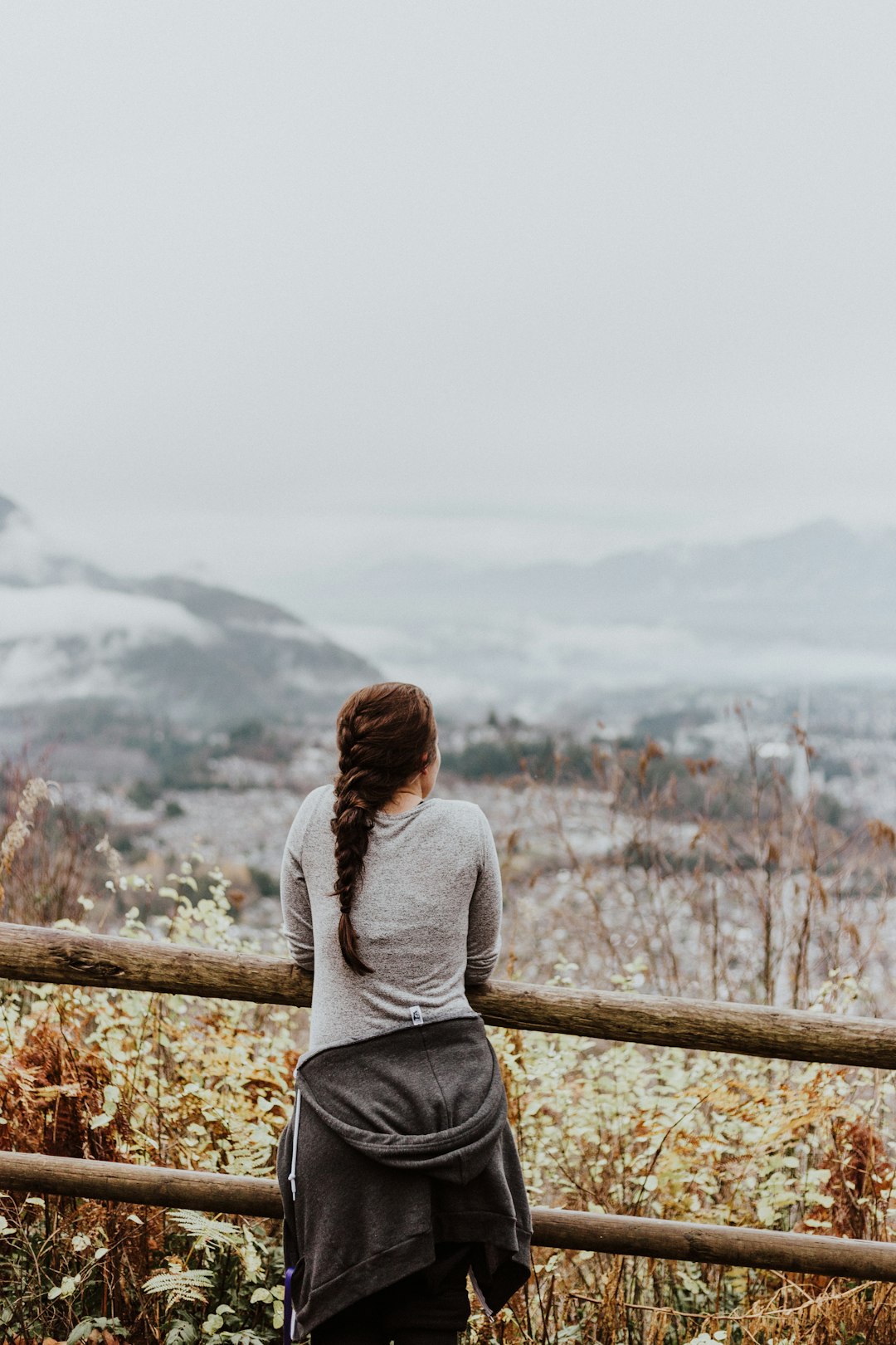 standing woman in grey long-sleeved shirt