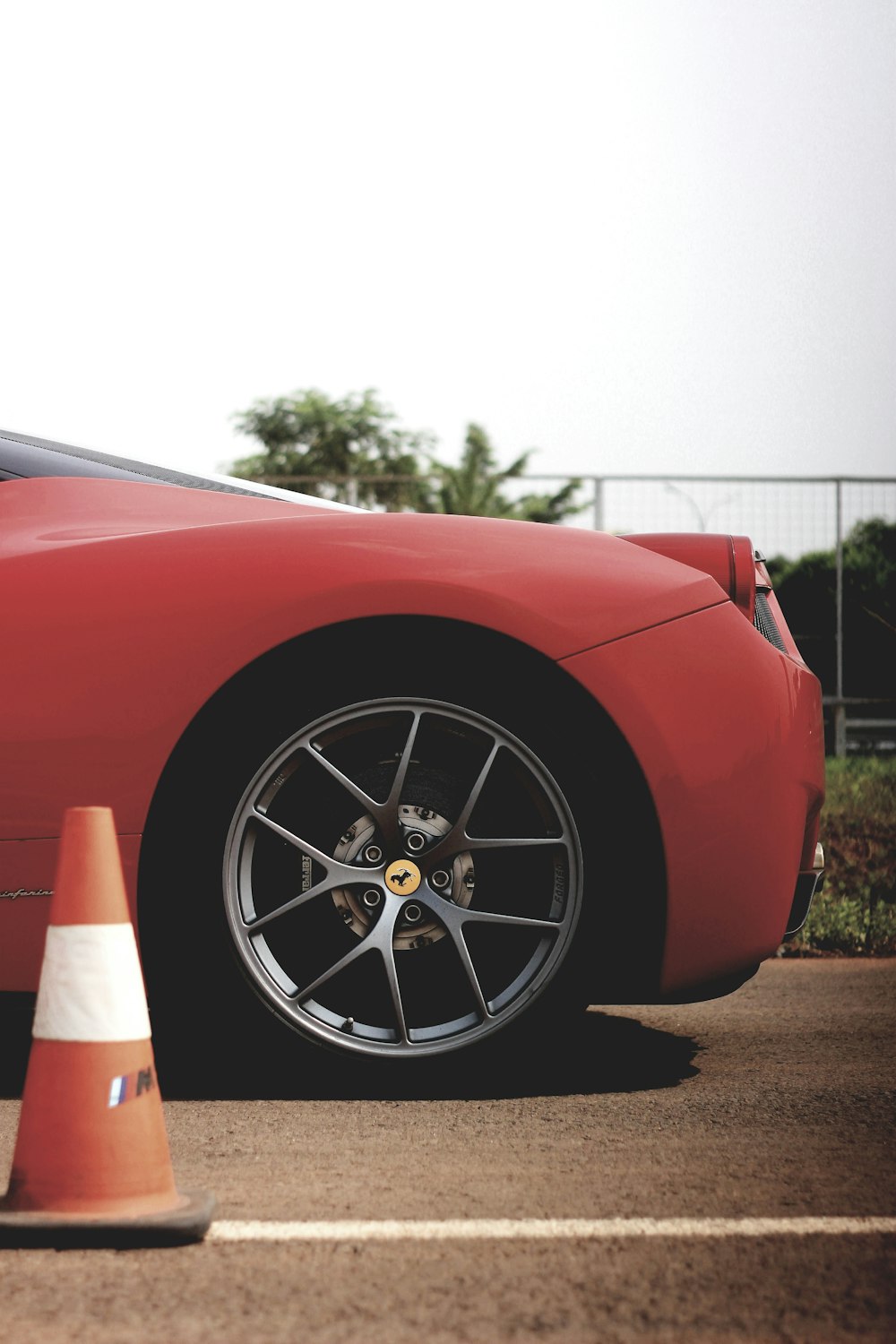 red Ferari vehicle beside traffic cone