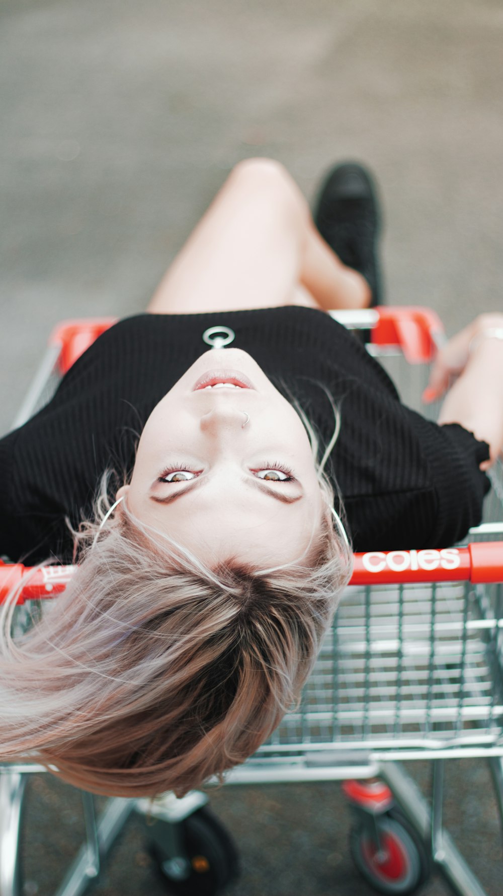 woman wearing black crew-neck shirt sitting on lounger at daytime