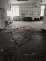 A wide shot of a minimal sound art setup with industrial elements arranged neatly on a white floor.