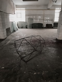 Modern geometric sculpture in a bright studio with natural light highlighting its sharp angles.