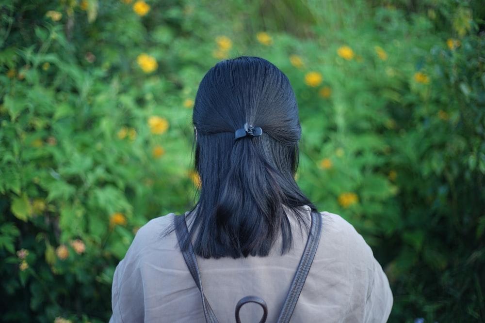 woman standing in front of yellow flowers