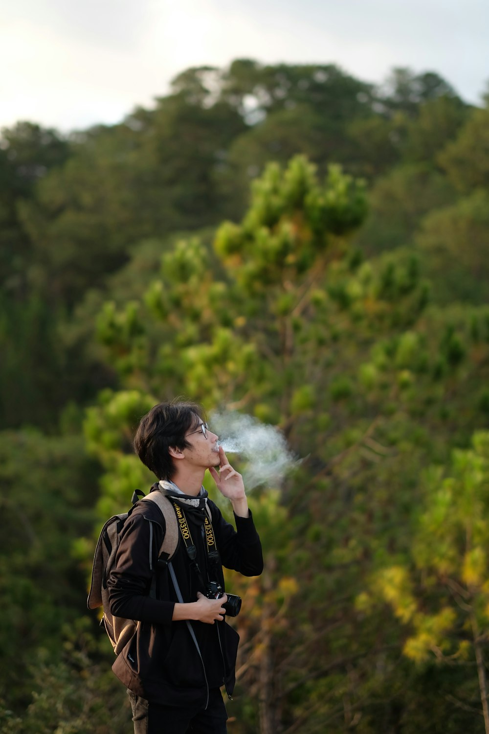 man in black long-sleeved shirt using cigarette