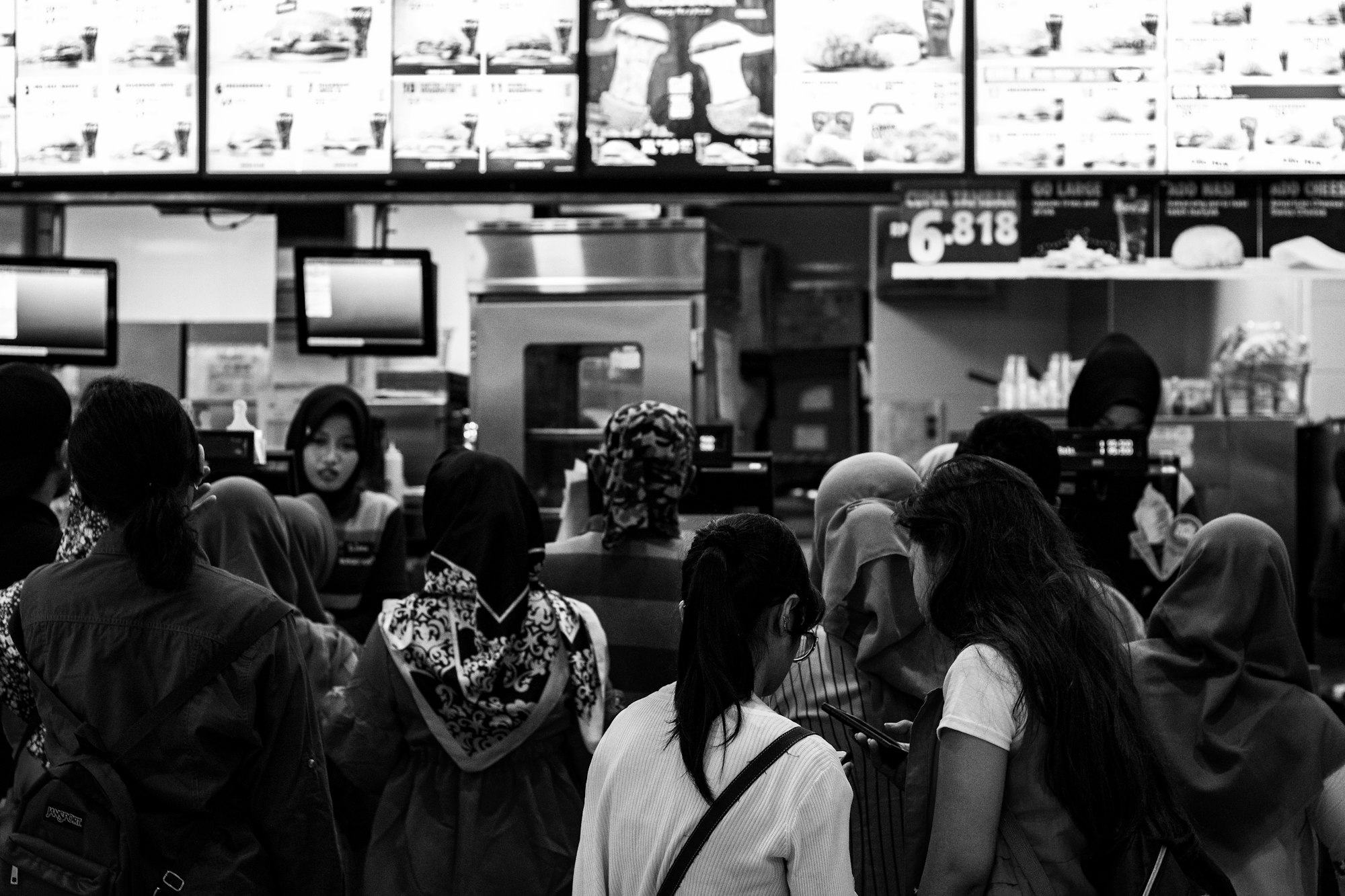 Distracted queue in fast food restaurant. Can you see the line which is better?