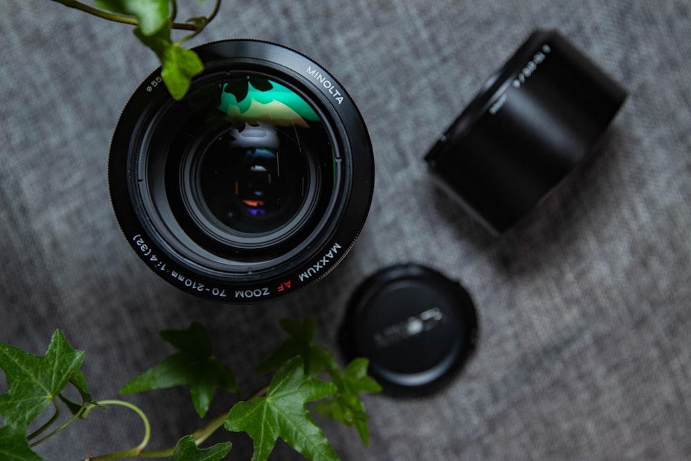 two black zoom lenses on gray linen