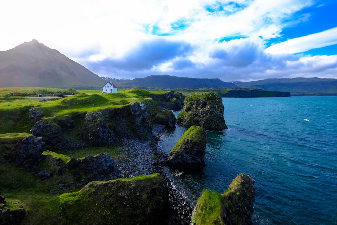 landscape photography of rock formation beside body of water