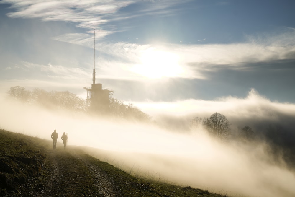 two person walking on dirt road during daytime