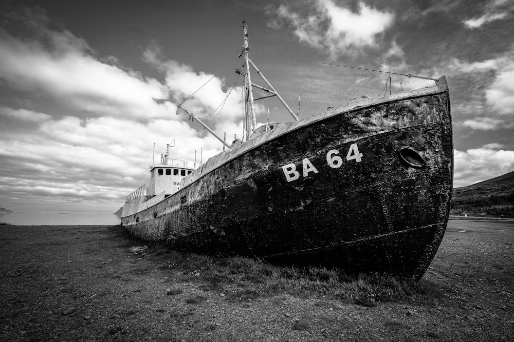 grayscale photography ship on sand