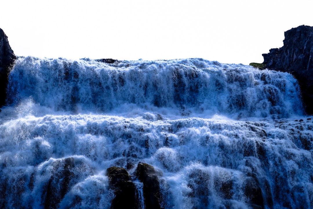 waterfalls under grey clouds