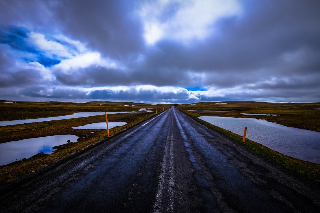landscape photo of road under cloudy sky
