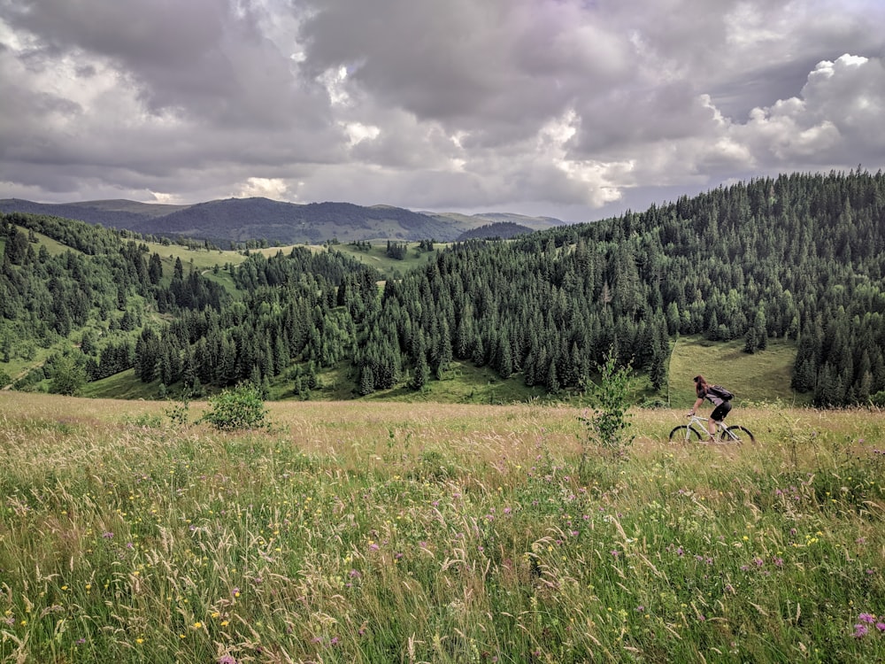 woman riding bicycle in green grass field