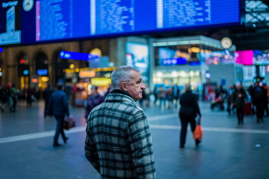 man in green and white plaid coat in busy city street