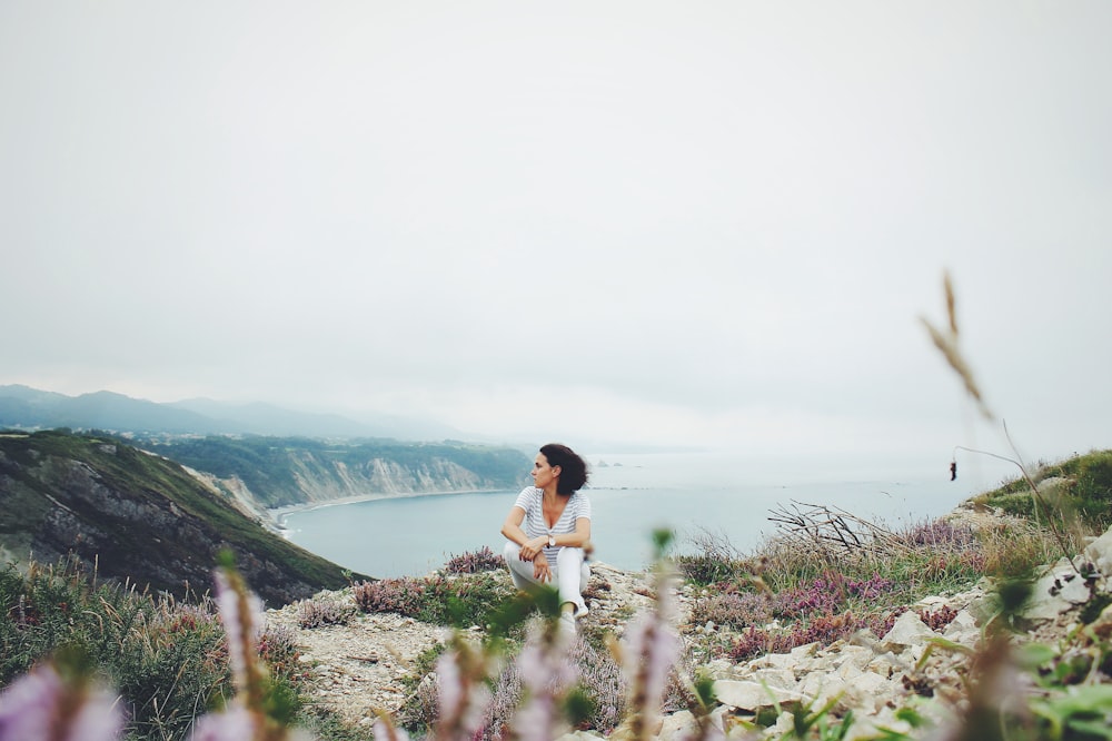 woman sitting near body of water