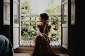 woman sitting on floor near window at daytime