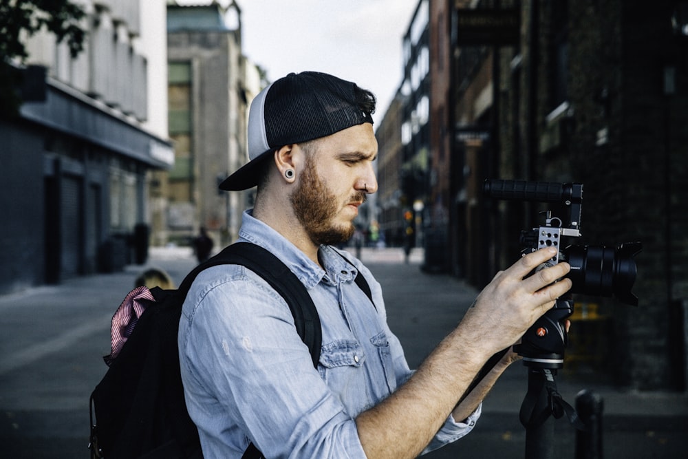 man using black DSLR camera