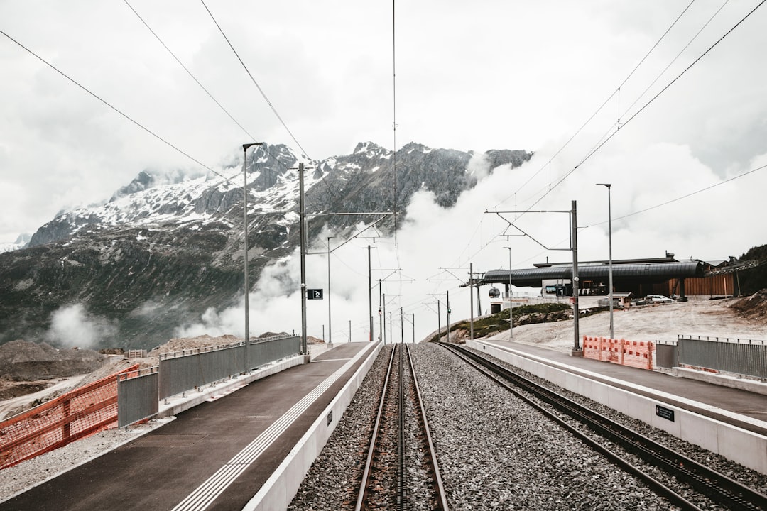 grey railway near houses, Since we were kids, my brother and I had only heard of the great Glacier Express. This year we finally got a taste of this deliciousness. Through tunnels and bridges and the mountains of Switzerland, took a moment to capture the road left behind, as the clouds rolled in.