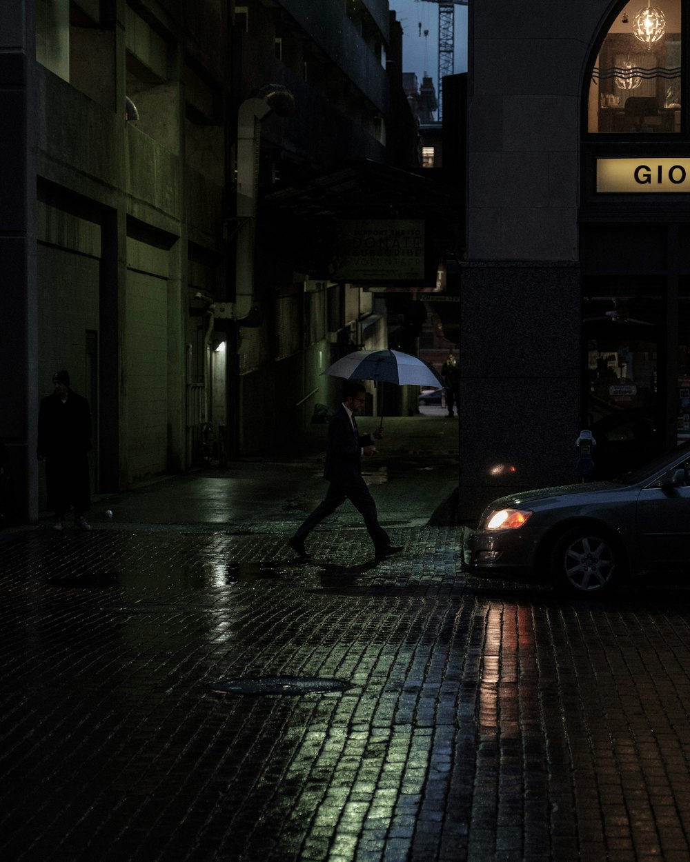 Foto hombre cruzando la calle con paraguas durante la noche – Imagen  Persona gratis en Unsplash