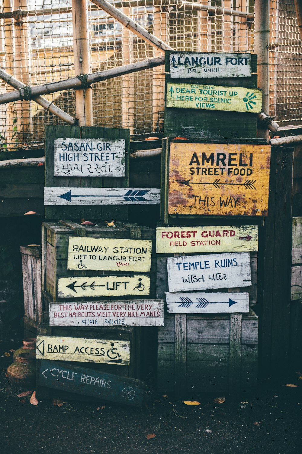 assorted street signs near white fence at daytime