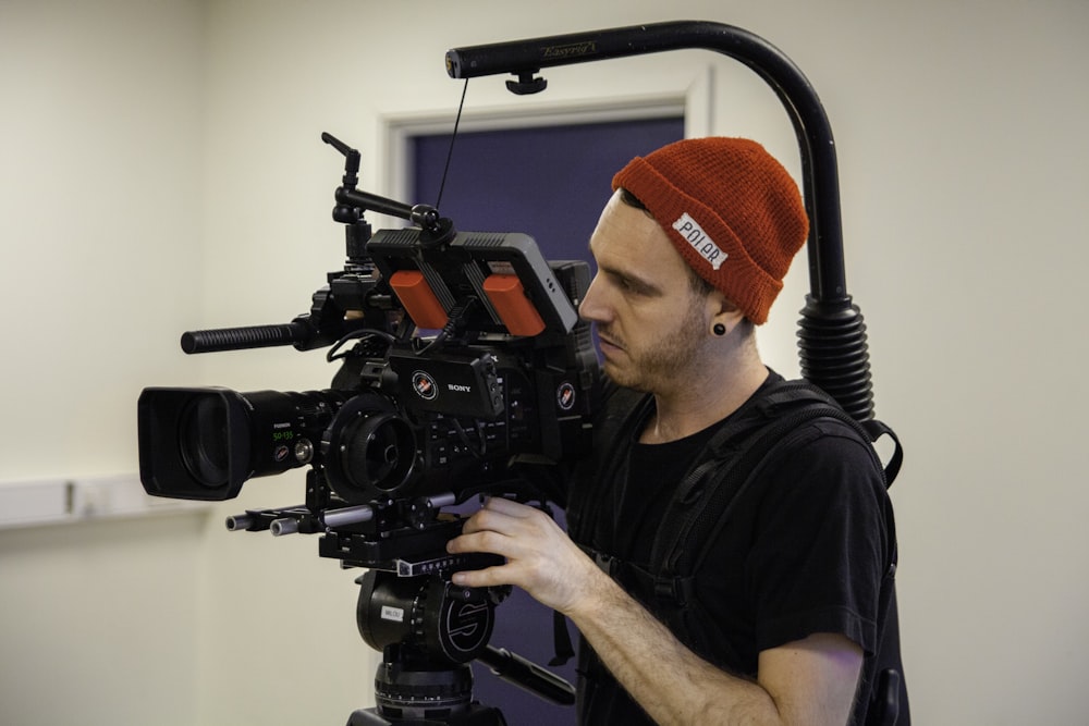 man in black shirt carrying movie camera with stabilizer