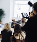 woman holding camera standing near people