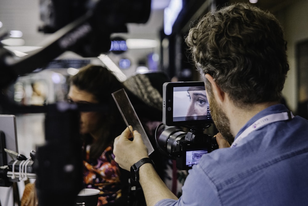 man standing and taking photo of woman