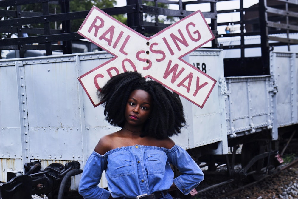 woman standing near railway sign