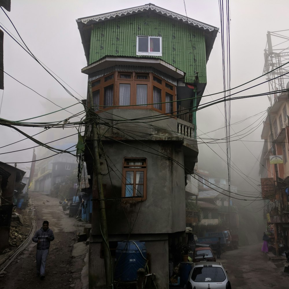 Casa de 2 pisos de concreto gris entre caminos