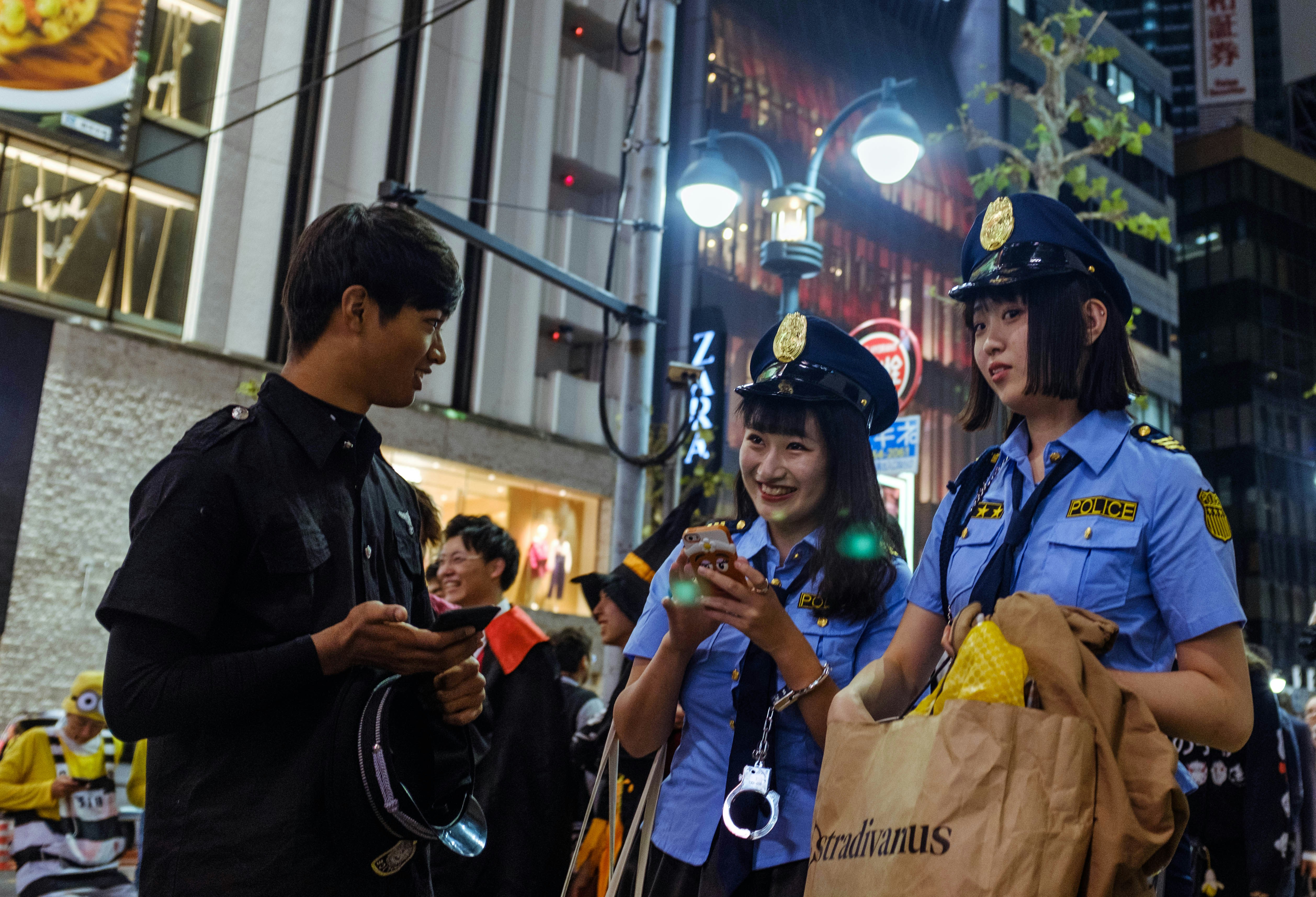man facing two police women at night time
