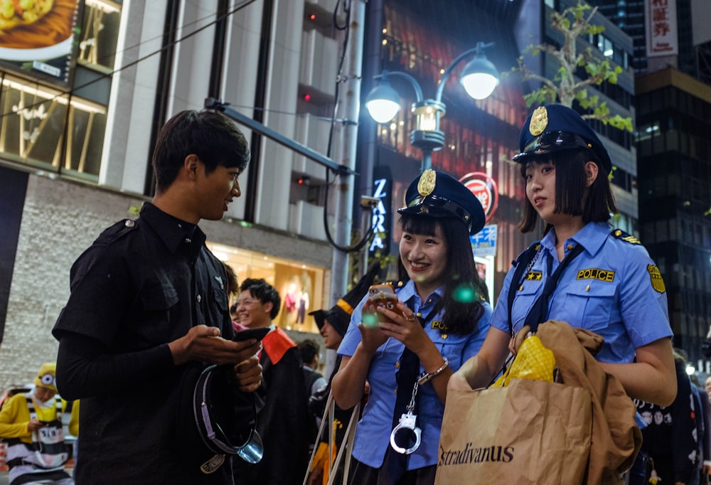 man facing two police women at night time