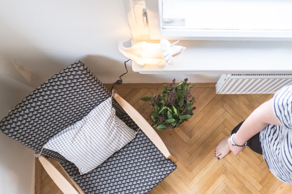 a woman sitting on a chair next to a plant