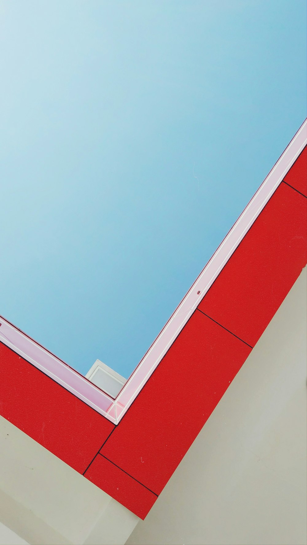 a red and white building with a blue sky in the background