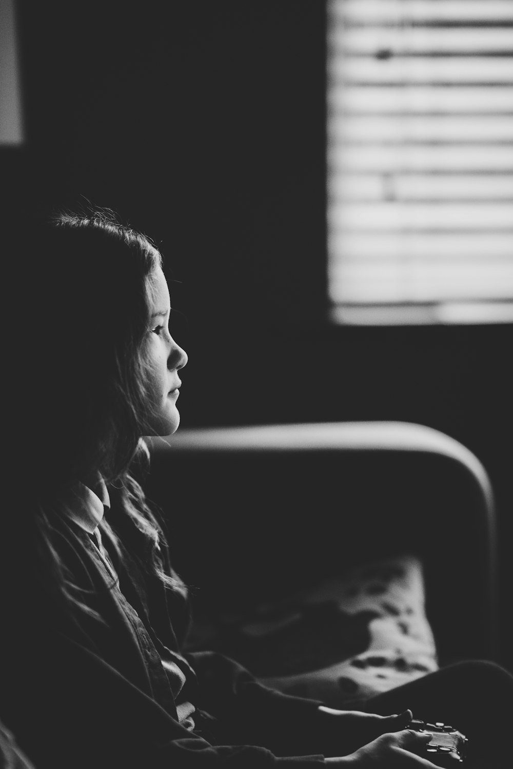 grayscale photo of girl sitting on sofa