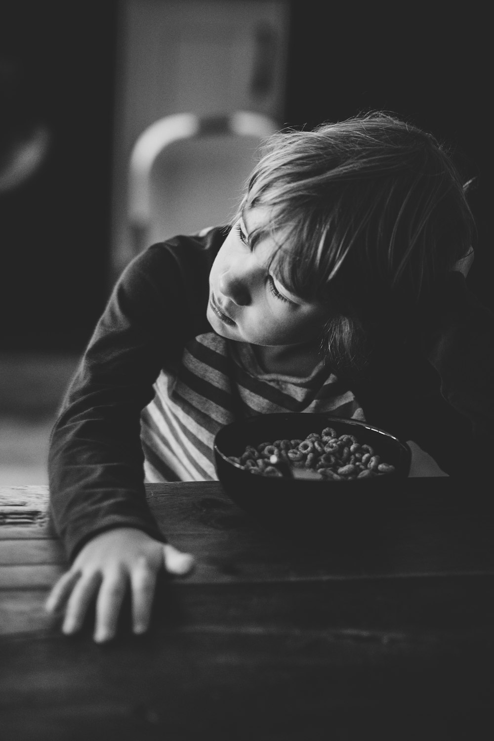 boy sitting by the table with bowl of cereals