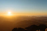 Mountain view from the hotel balcony during sunrise with soft golden light.