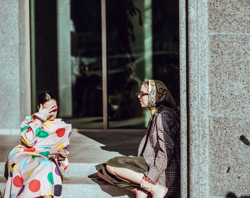 duas mulheres sentadas em escadas