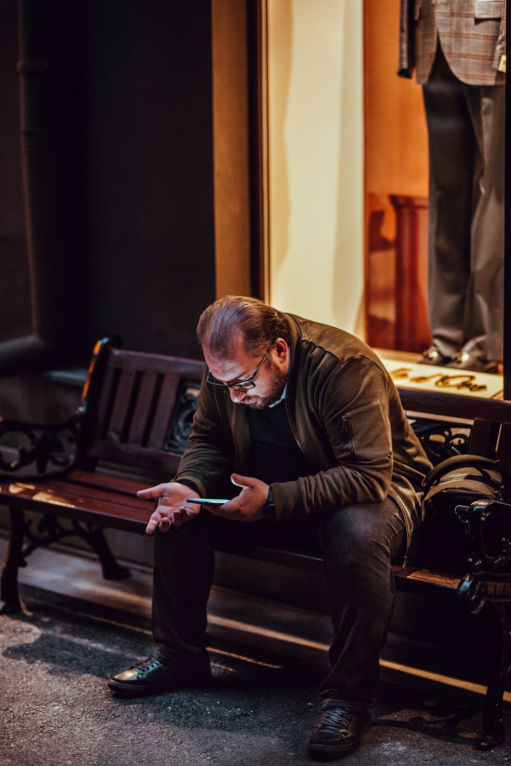 Hombre sentado en el banco usando un teléfono inteligente